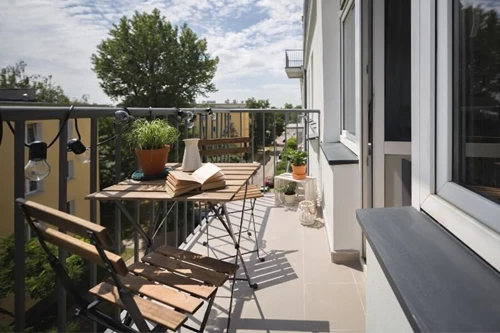 Balcony Patio With String Lights Draped On Deck Railing Showcasing Creative Balcony Lighting Ideas