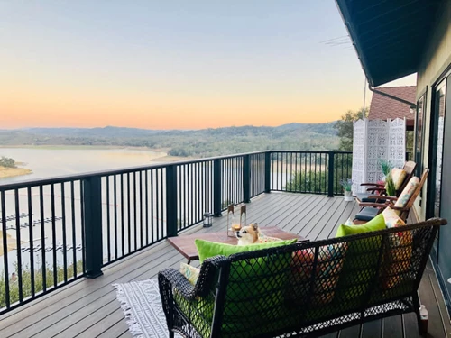 Lounge Furniture On Second Story Deck Overlooking River And Rolling Hills Landscape