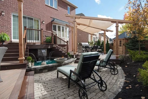 Stone patio with fountain and lounge chairs White brick patio with fountain and lounge chairs